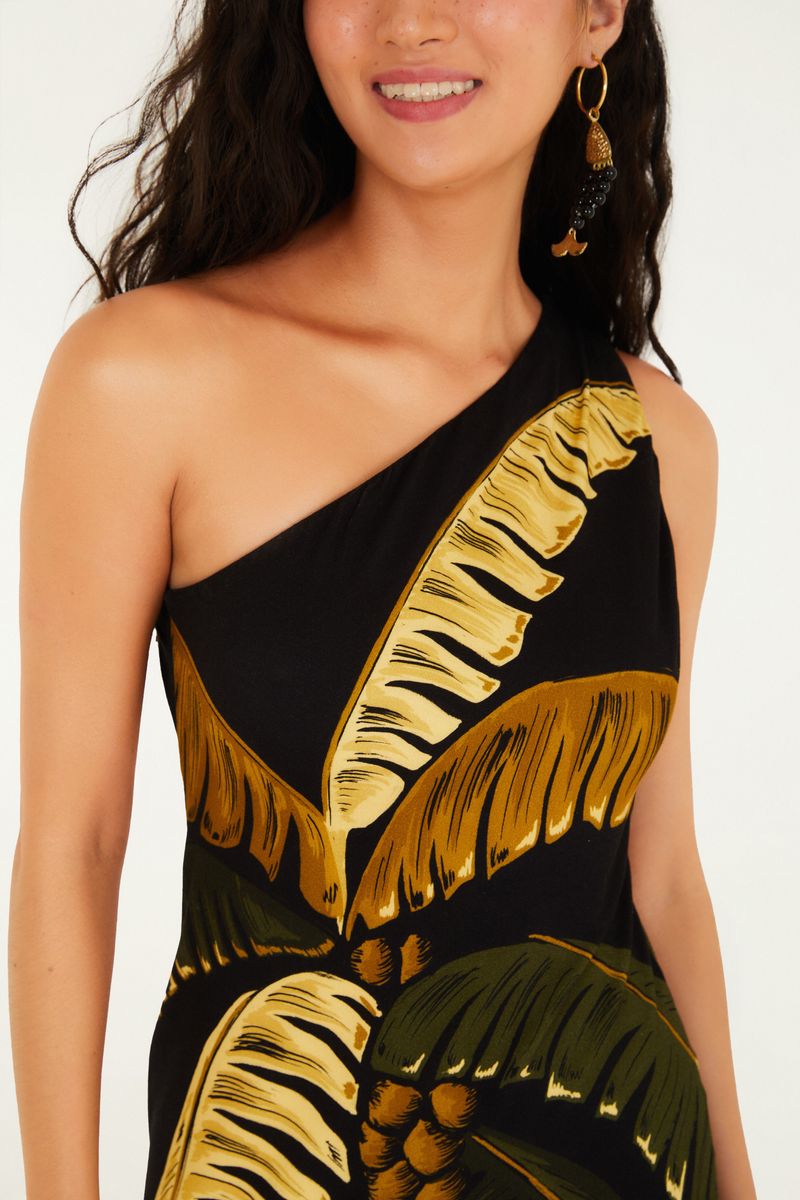 Detalle del escote asimétrico del vestido con estampado de palmas.