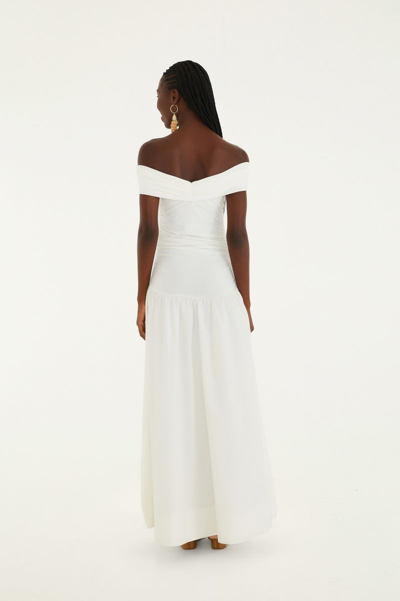 Detalle de la parte inferior del vestido blanco con pliegues.