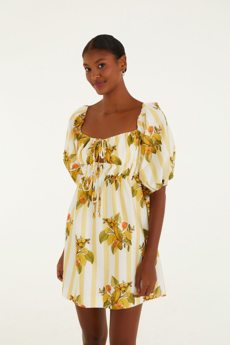Vista lateral del vestido corto con estampado de frutas y rayas, mostrando el ajuste en la cintura.