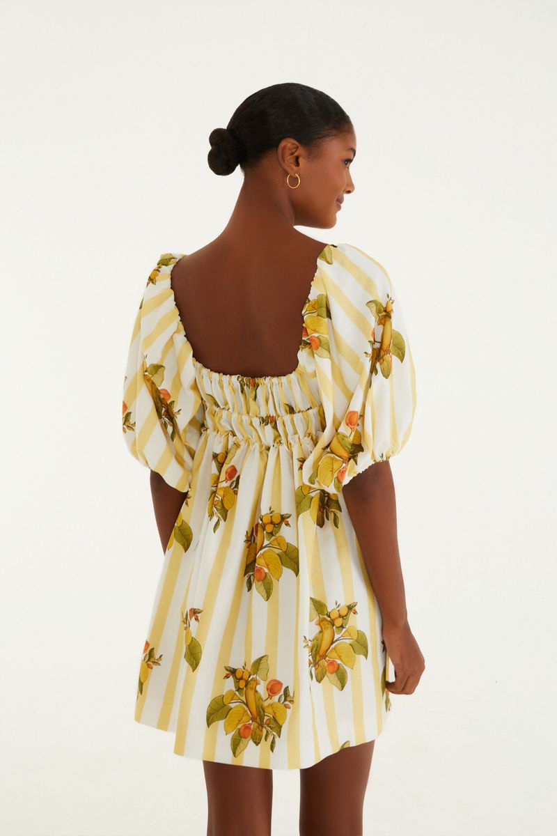Detalle del escote cuadrado y tirantes abullonados del vestido corto con estampado de frutas y rayas.