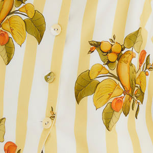 Detalle del estampado botánico del chaleco Pájaro Chic con pájaros y hojas.
