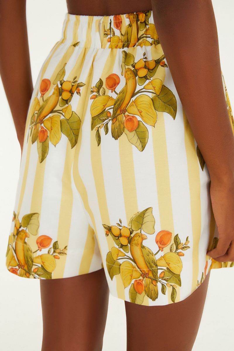 Detalle lateral de los pantalones cortos estampados con pájaros y frutas.