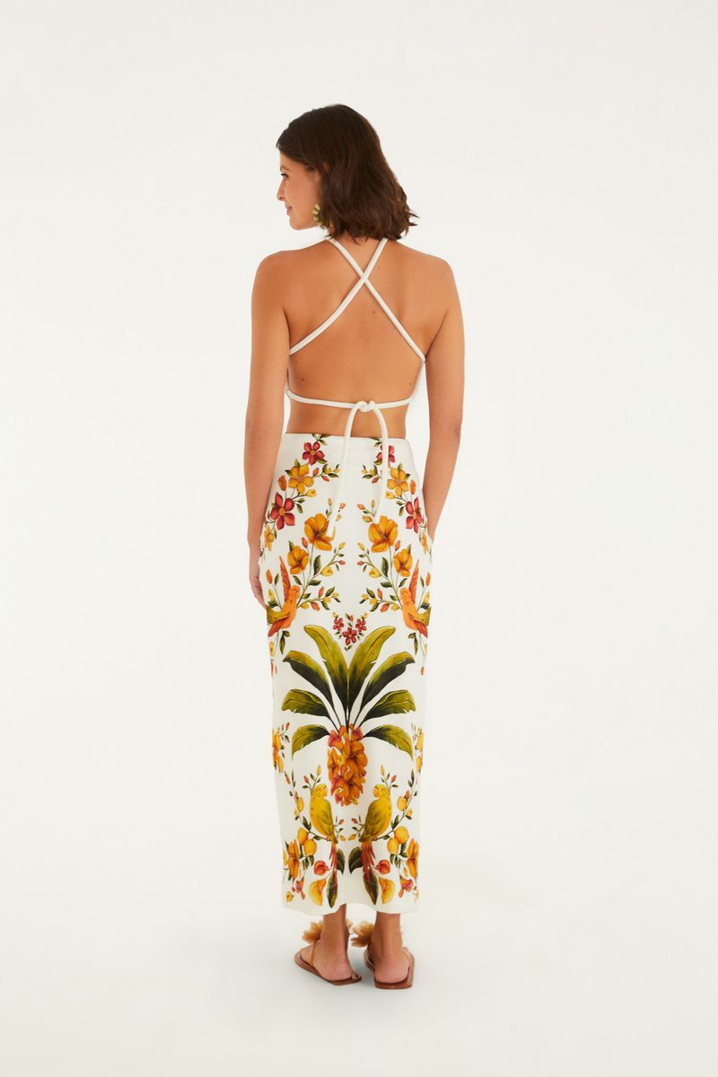 Vista lateral del vestido midi con estampado floral vibrante, destacando el diseño de la espalda.