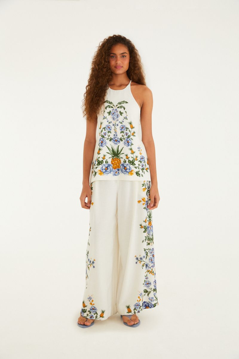 Blusa floral con amarre vista de cuerpo entero, combinada con pantalón estampado.