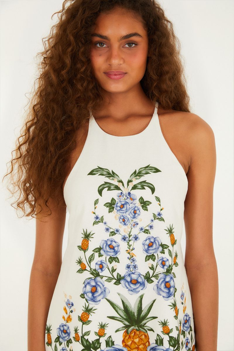 Detalle del estampado floral de la blusa, mostrando flores botánicas y elementos tropicales.