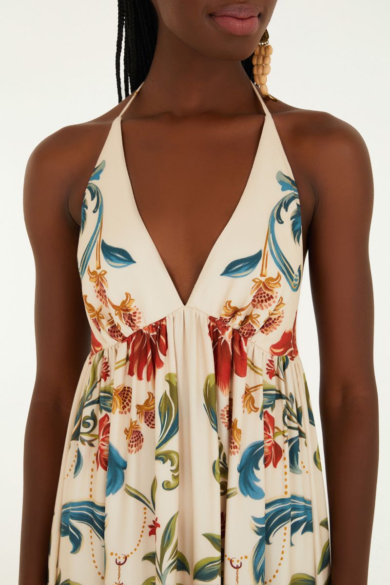 Vestido con estampado, tirantes finos y escote profundo, exhibido en modelo de espaldas.