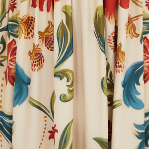 Plano cercano del estampado floral y botánico del vestido, destacando los elementos decorativos.