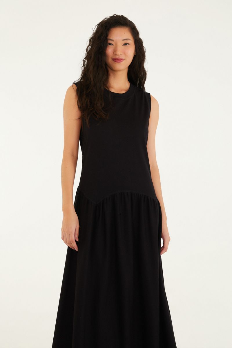 Vestido regata cropped negro visto de perfil, destacando el ajuste cómodo y el estilo moderno.