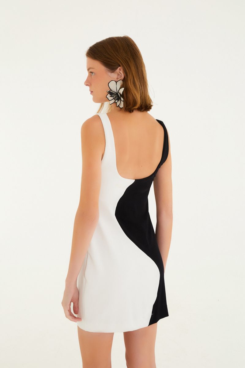 Vista trasera del vestido corto de parches colmena, destacando el diseño en negro y blanco.