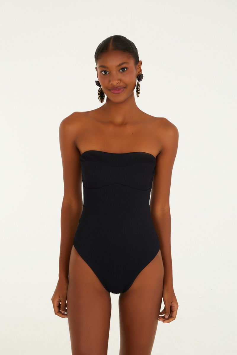 Modelo vistiendo un body negro sin tirantes de canalé, vista frontal.