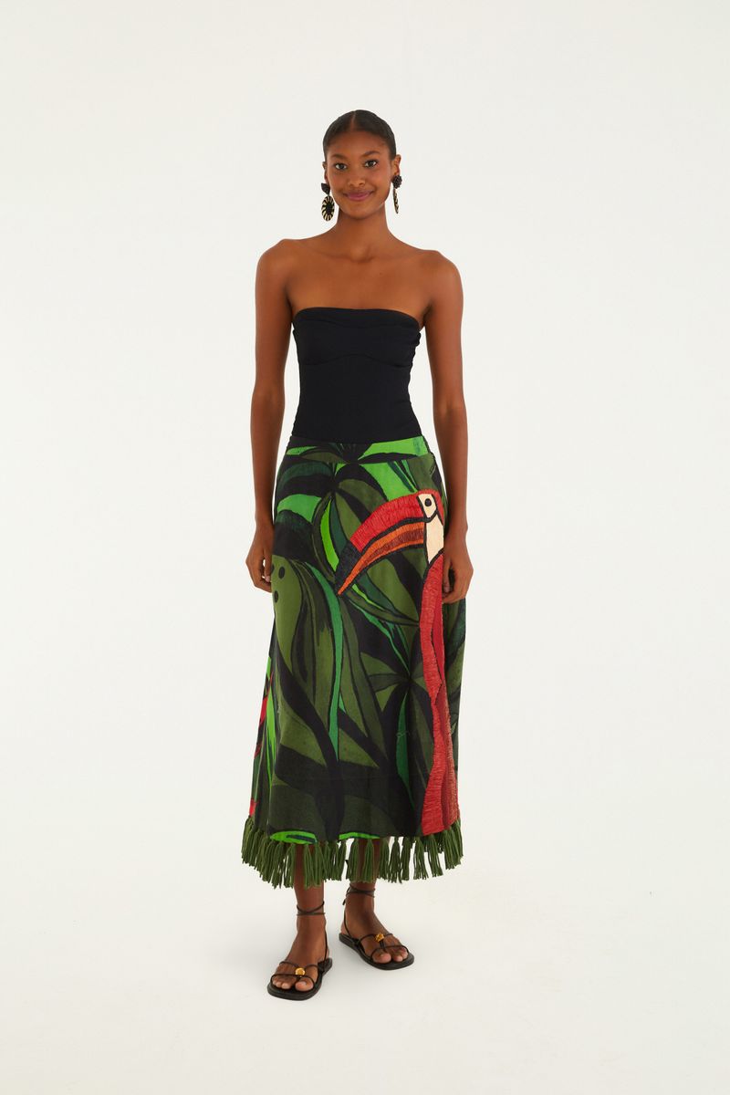 Modelo vistiendo un body negro sin tirantes de canalé, combinado con una falda larga estampada tropical, vista trasera.