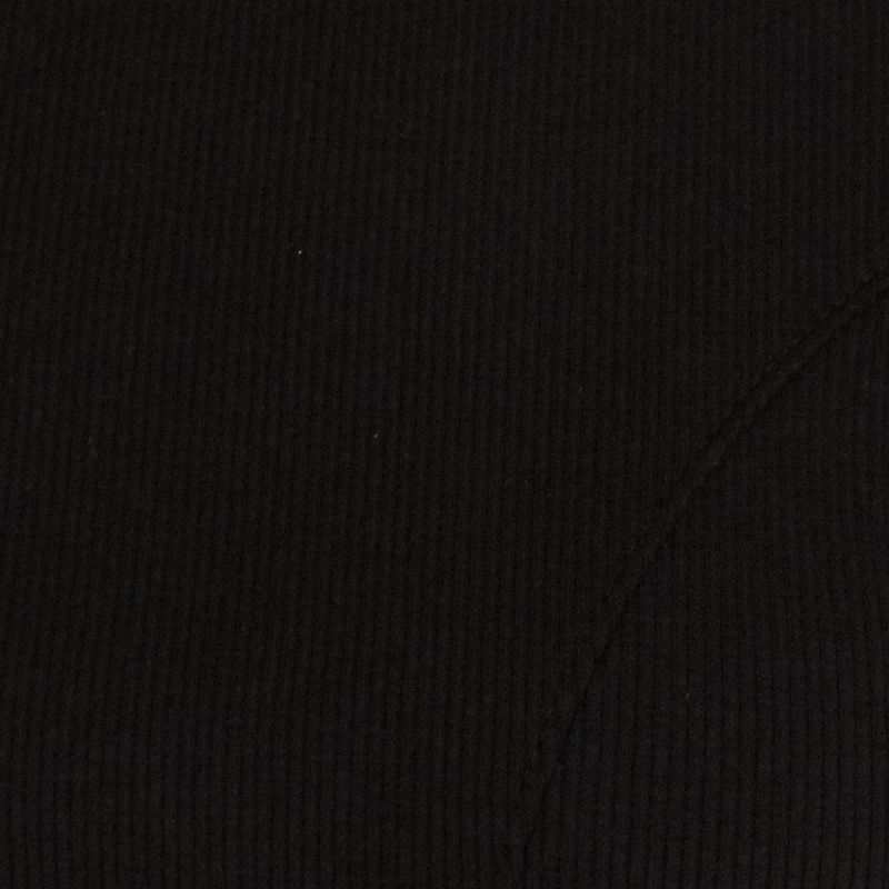 Close-up del tejido de canalé negro con pespunte de la camiseta.