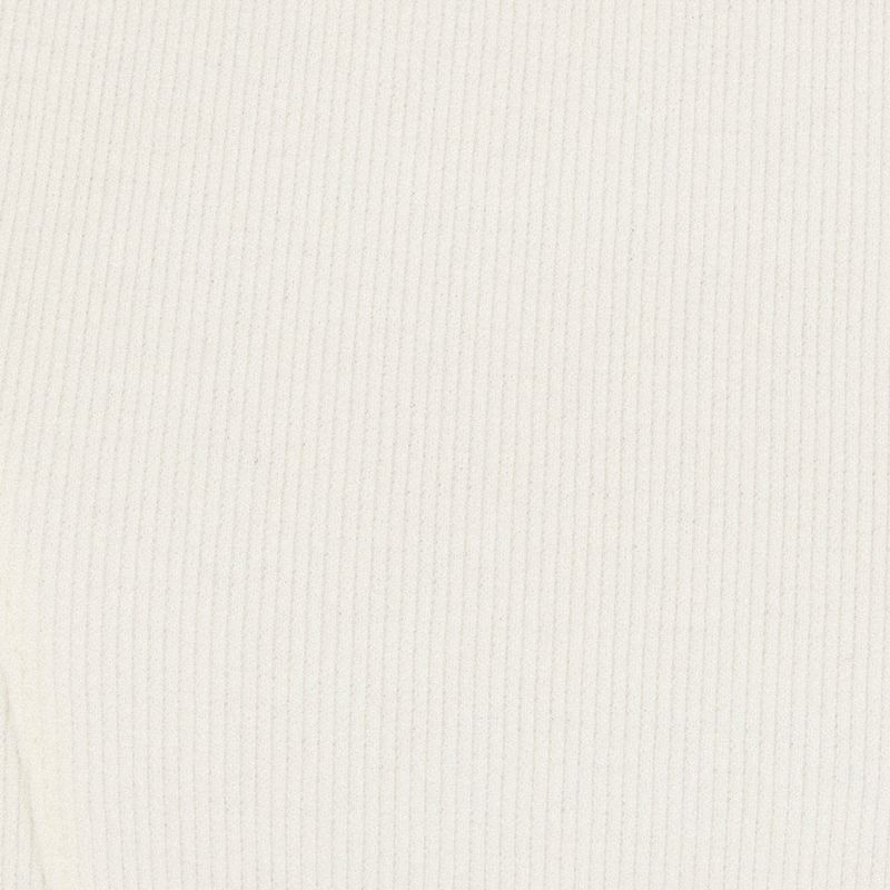 Detalle del tejido de la camisa blanca, resaltando la textura rib.