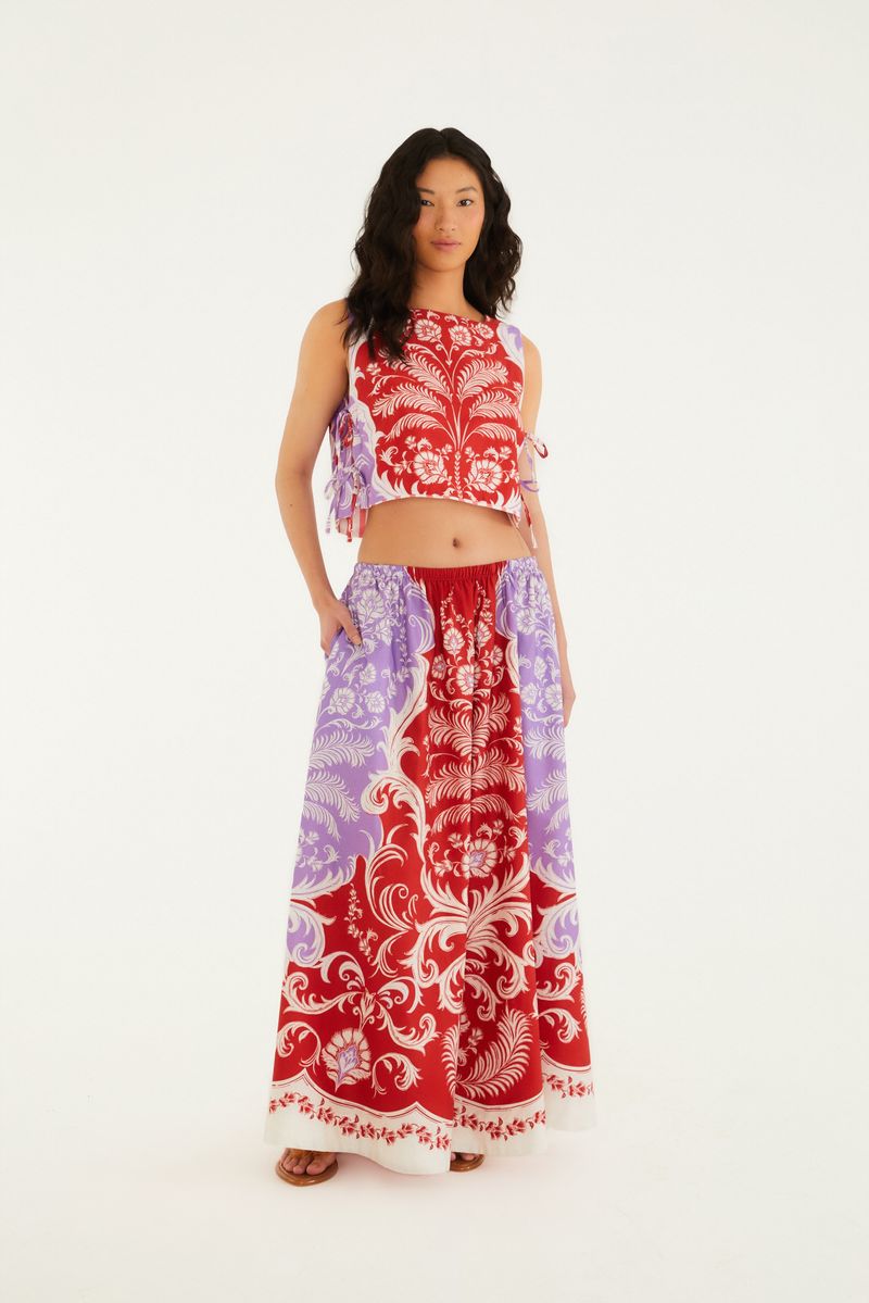 Imagen de una falda larga estampada con patrón ornamental en rojo y lila, vista frontal.