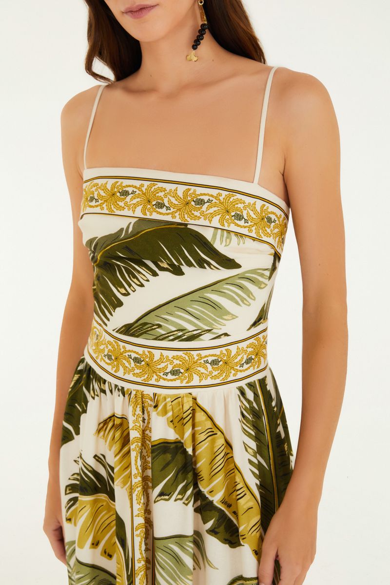 Detalle del corpiño del vestido con estampado de hojas y ornamentos dorados.