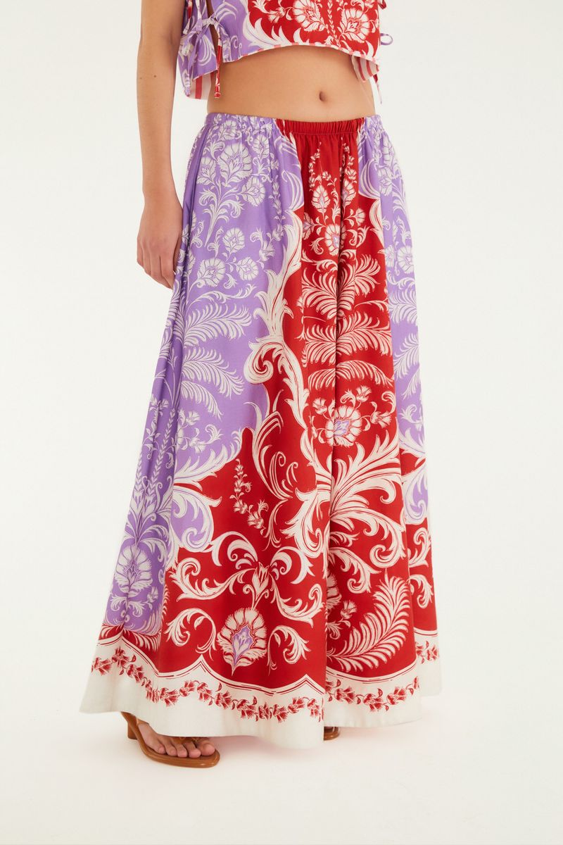 Imagen de una falda larga estampada con patrón ornamental en rojo y lila, vista trasera.