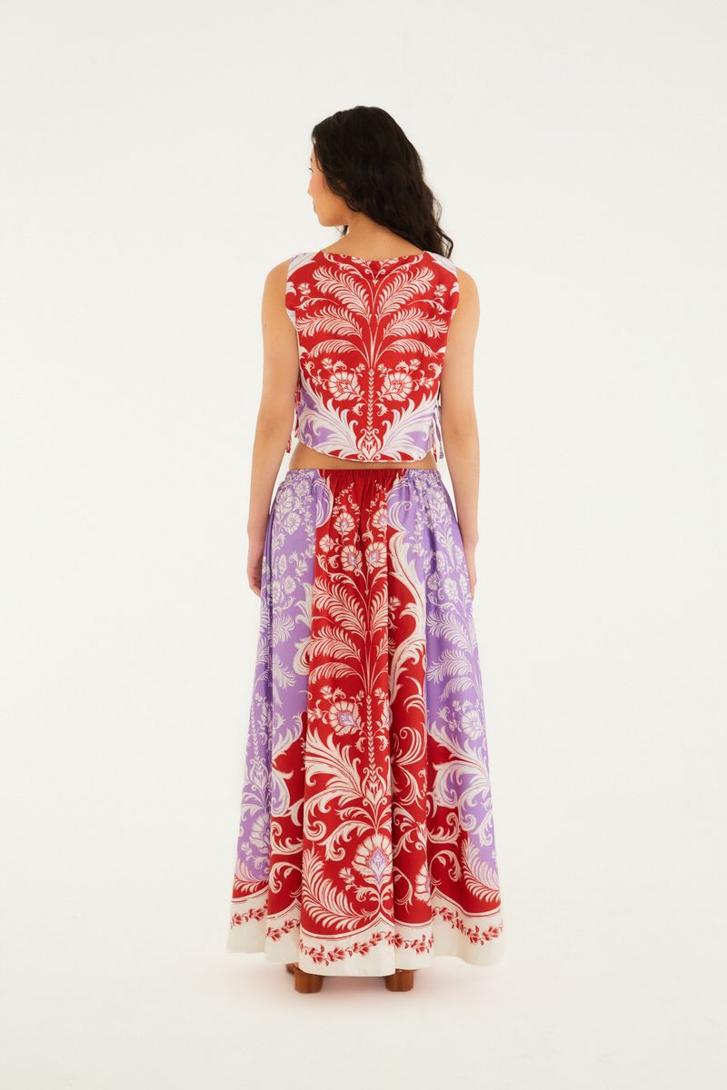 Imagen de detalle del estampado ornamental en rojo y lila de la falda.