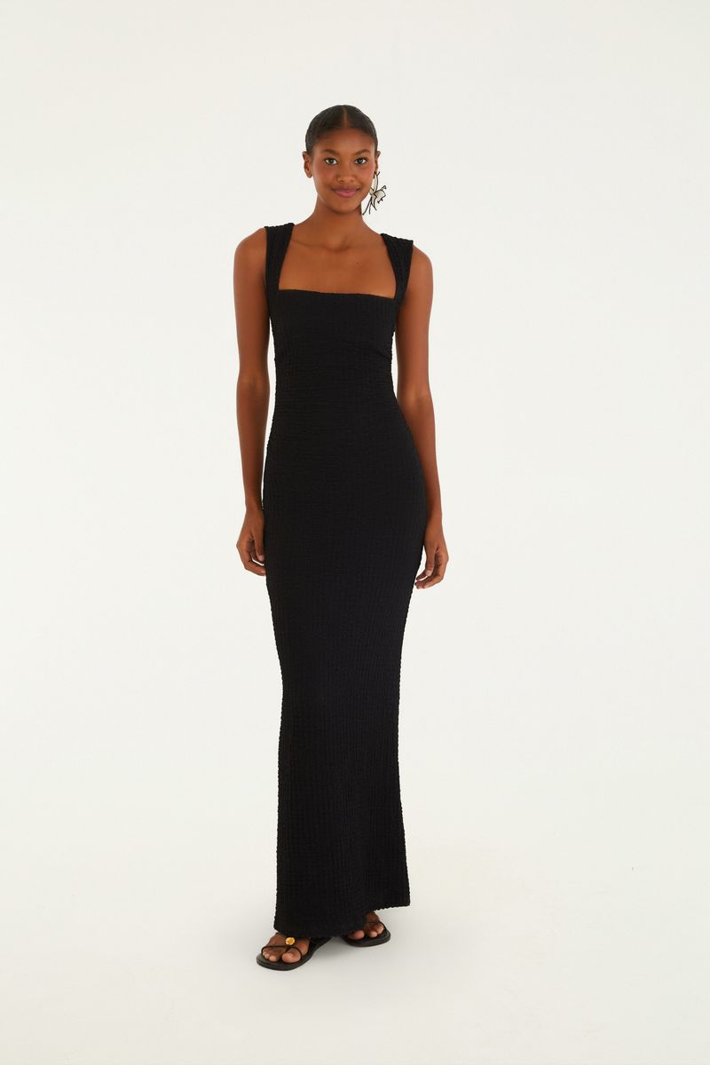 Vestido midi negro con tirantes torcidos visto de frente, destacando el ajuste al cuerpo y el largo.