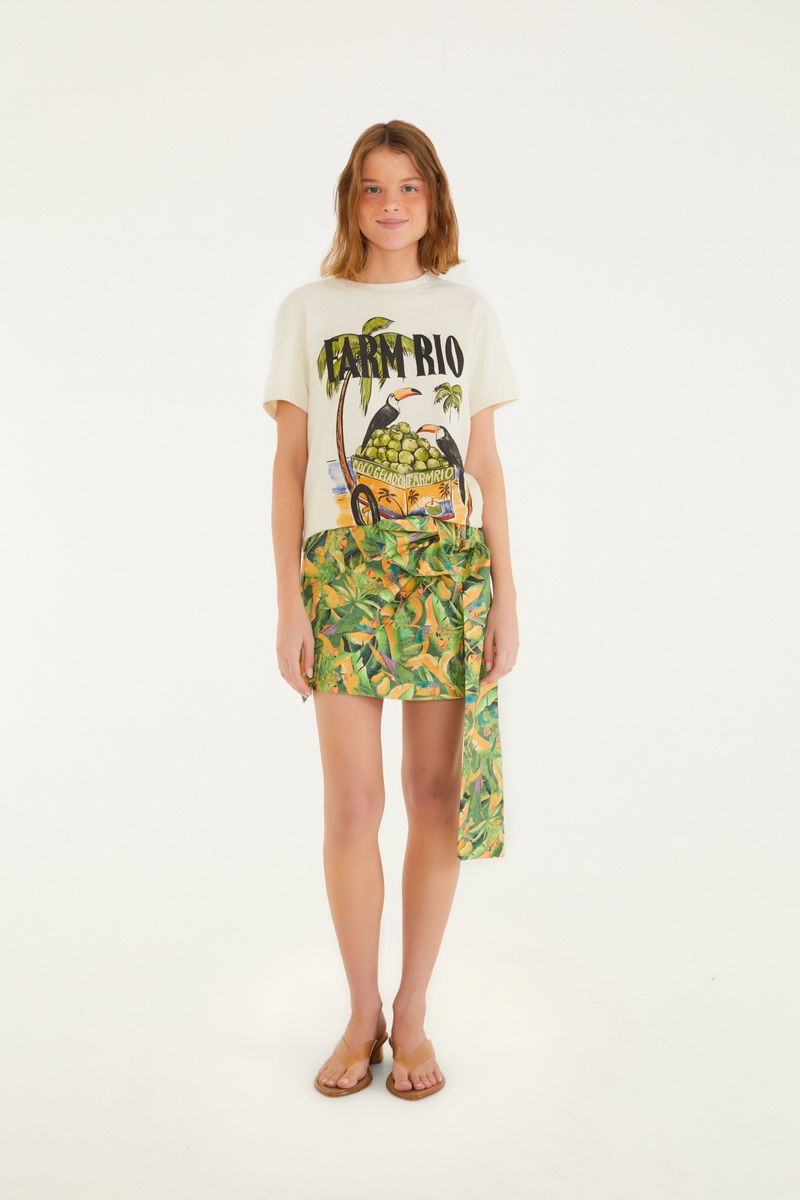 Vista completa de la camiseta con estampado tropical, combinada con falda.