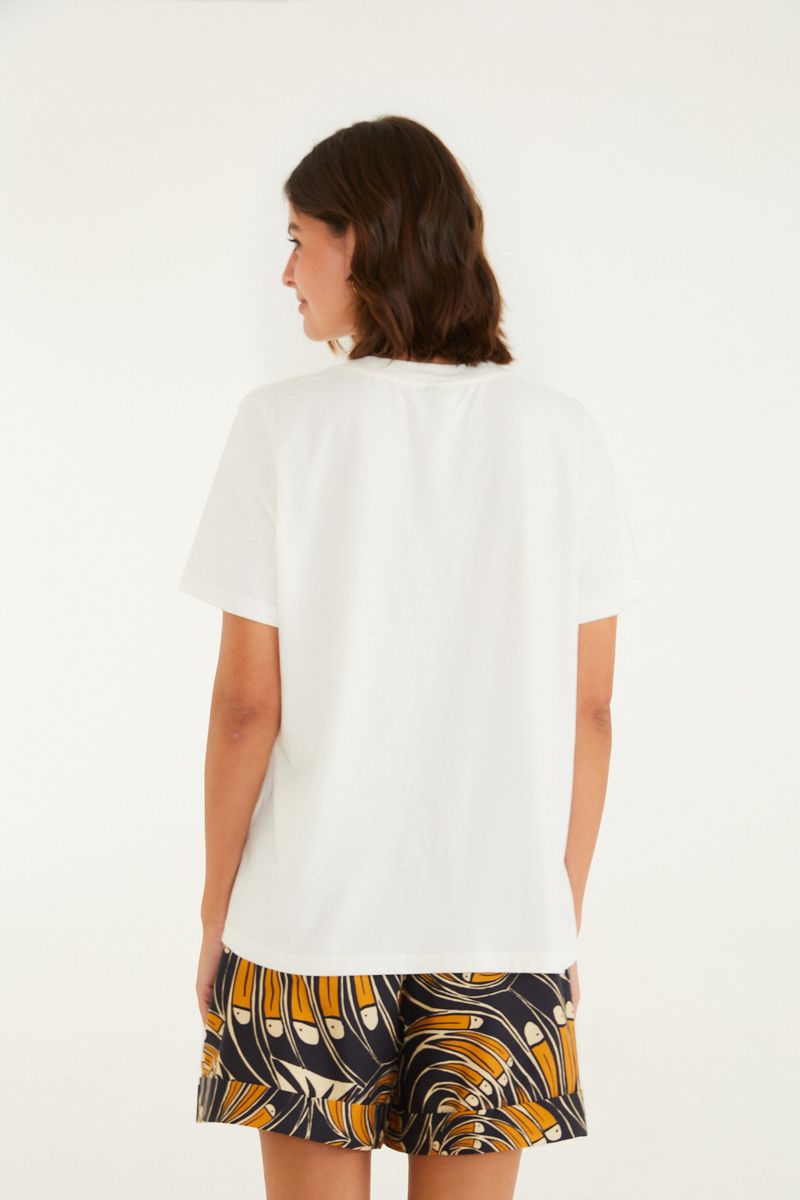 Vista trasera de la camiseta blanca con diseño sencillo.