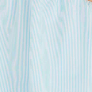 Vista posterior de la blusa, destacando su caída holgada y diseño asimétrico.