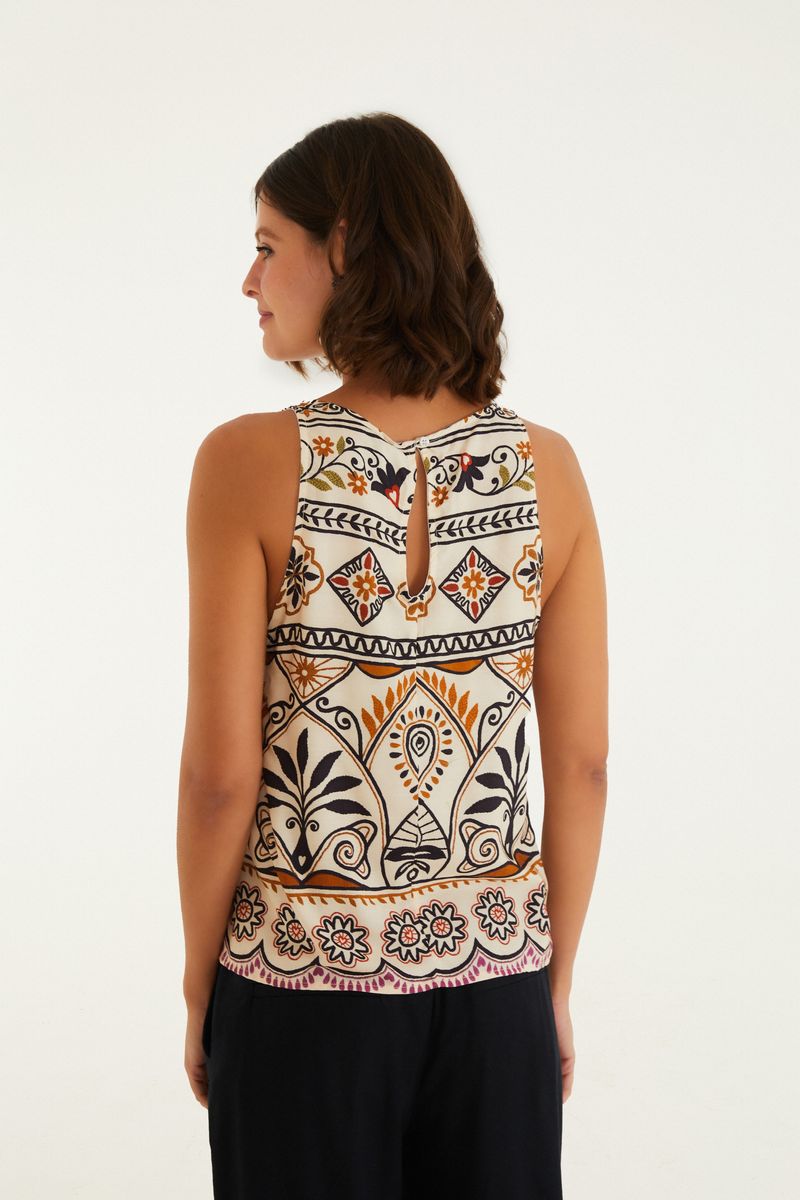Imagen mostrando una mujer vistiendo un vestido corto con estampado geométrico y floral, vista trasera.