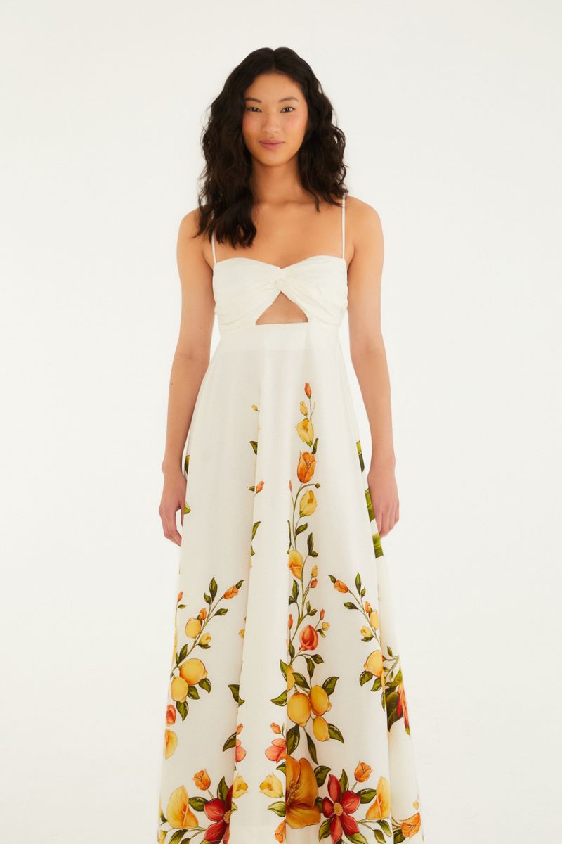 Vestido largo sin mangas con estampado floral sobre fondo blanco, visto desde atrás.