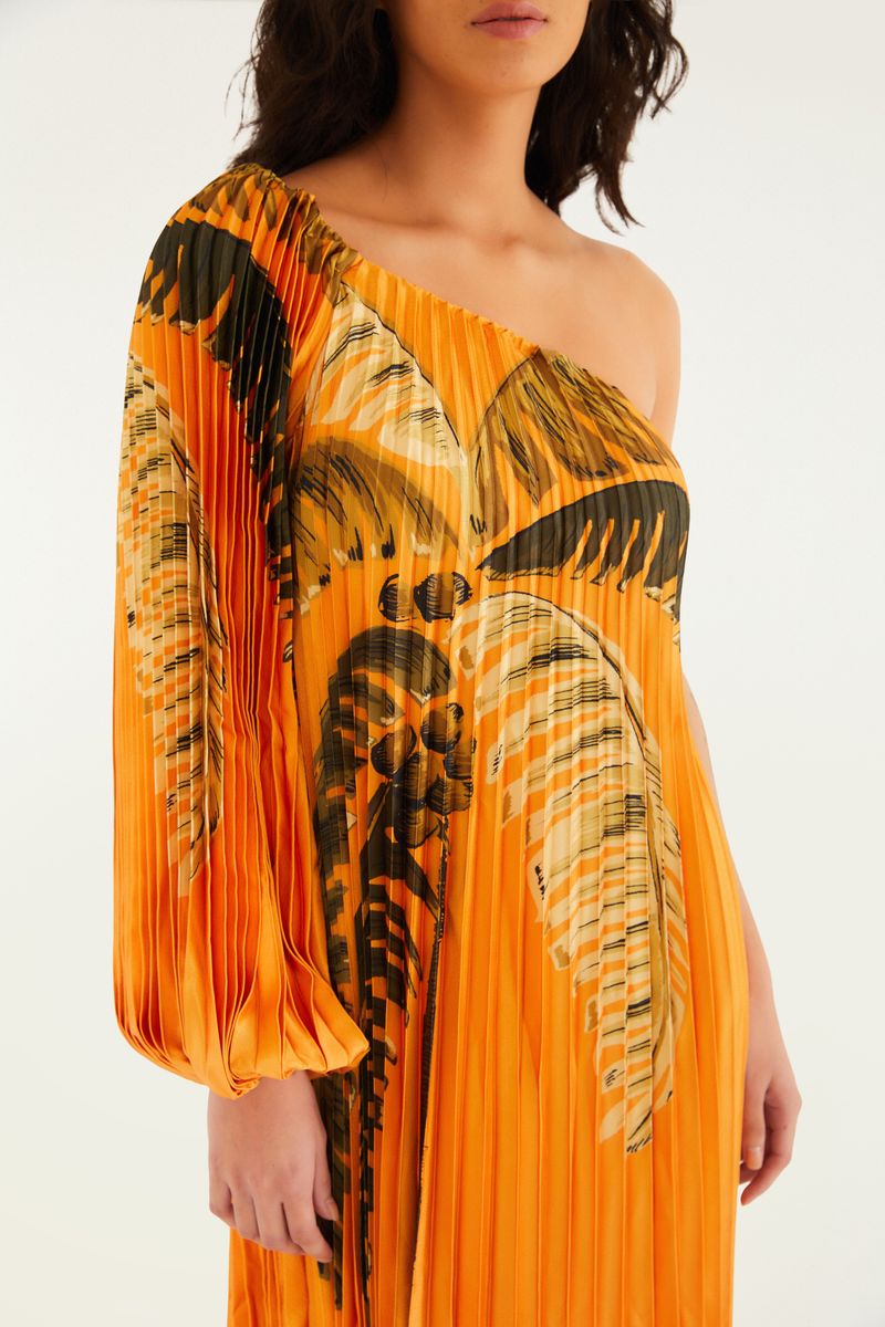 Detalle de la manga larga plisada del vestido con estampado tropical.