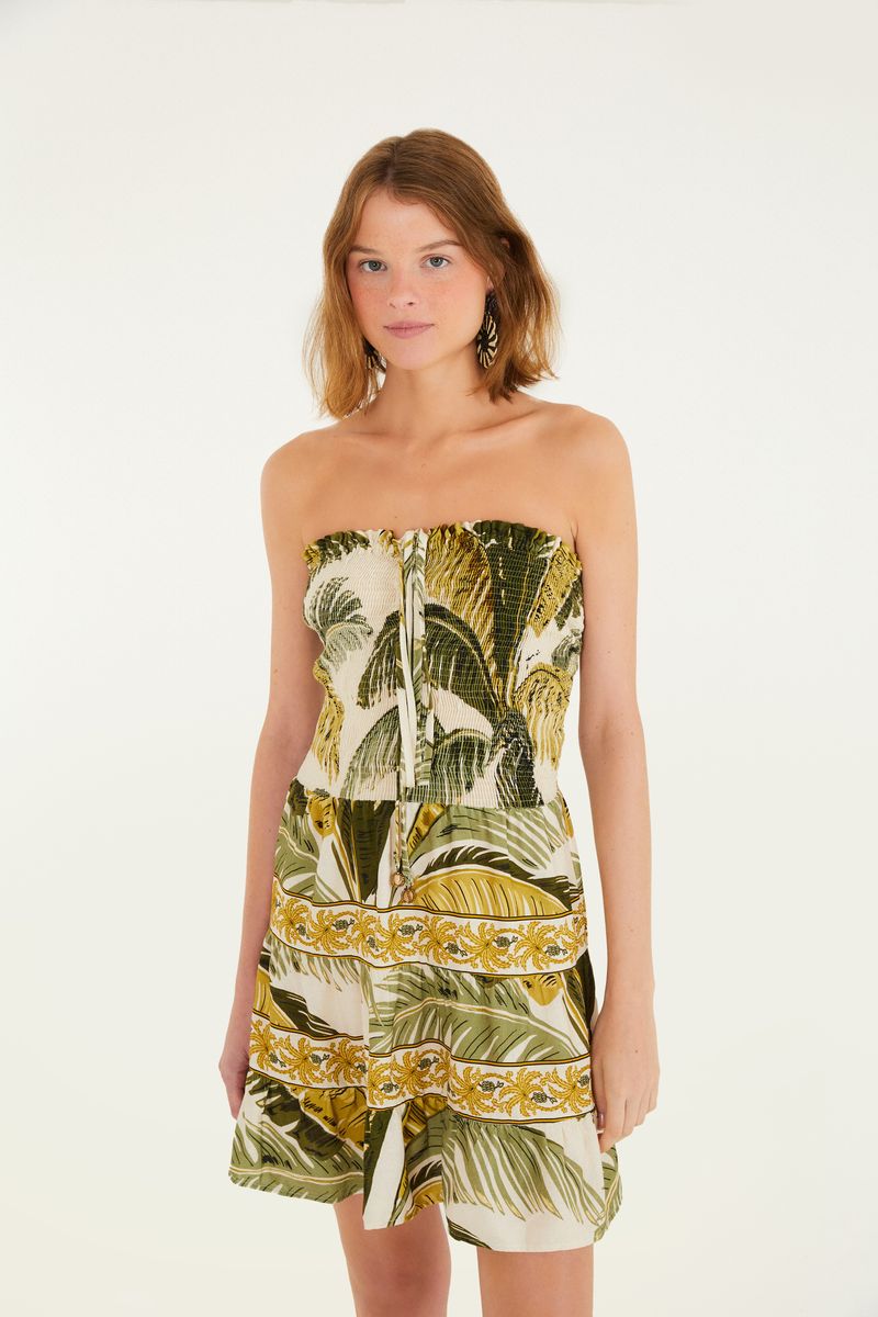 Vista trasera del vestido corto estampado, mostrando el detalle del amarre en el cuello y el diseño tropical.