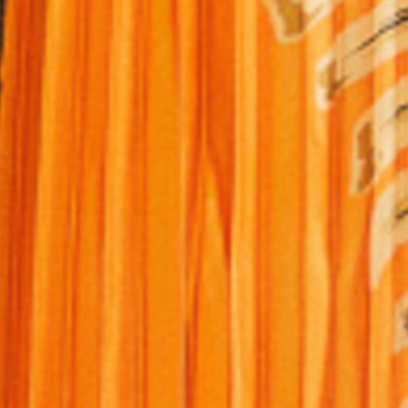 Close-up del estampado tropical en tonos de naranja y negro en el tejido plisado.
