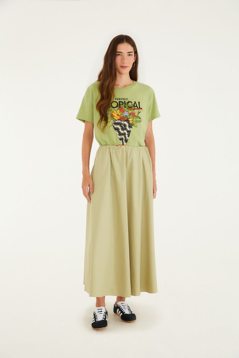 Modelo vistiendo camiseta verde con estampado tropical, vista completa.