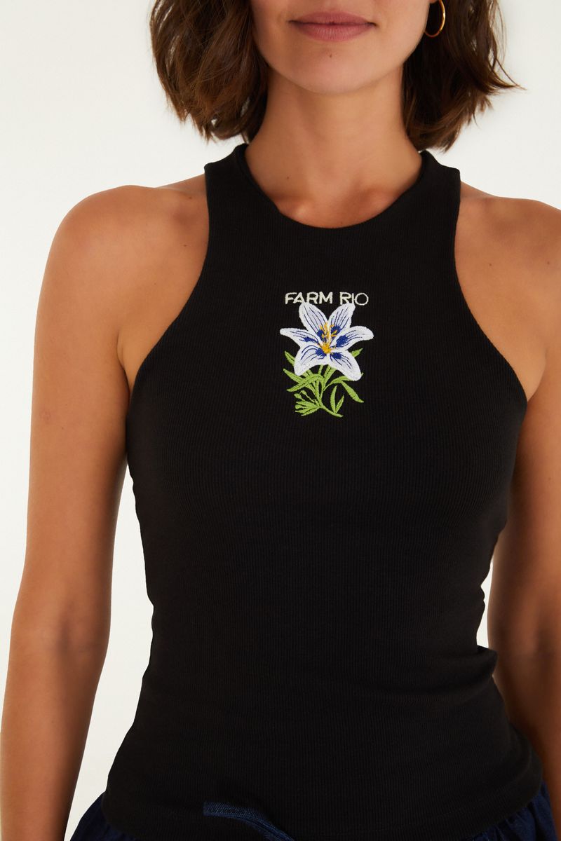 Regata negra con cuello alto y bordado floral, vista trasera.