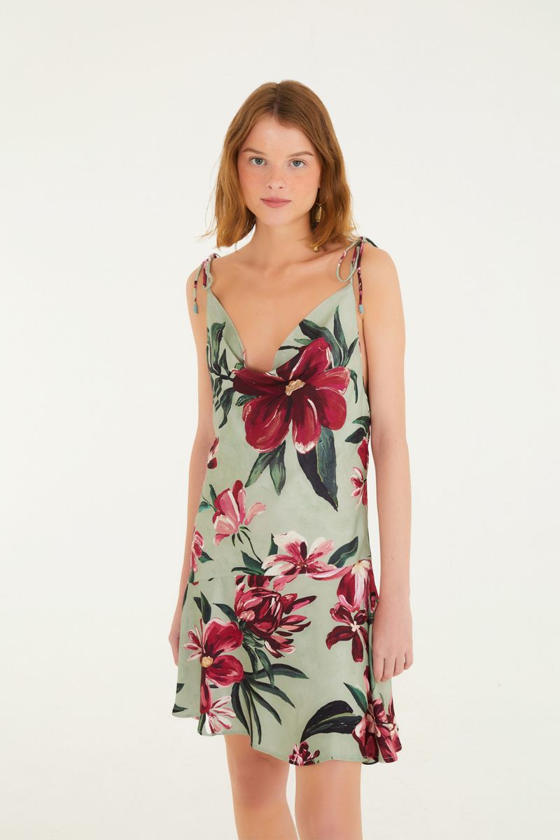 Vestido corto con tirantes finos y estampado floral en tonos de rojo y verde, visto de frente.
