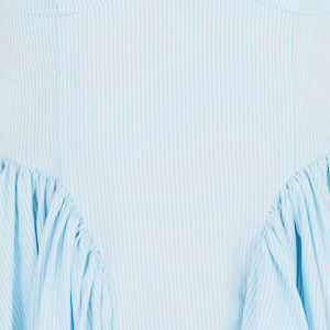 Vestido corto azul claro con falda fluida y detalles de pliegues, mostrado de lado.
