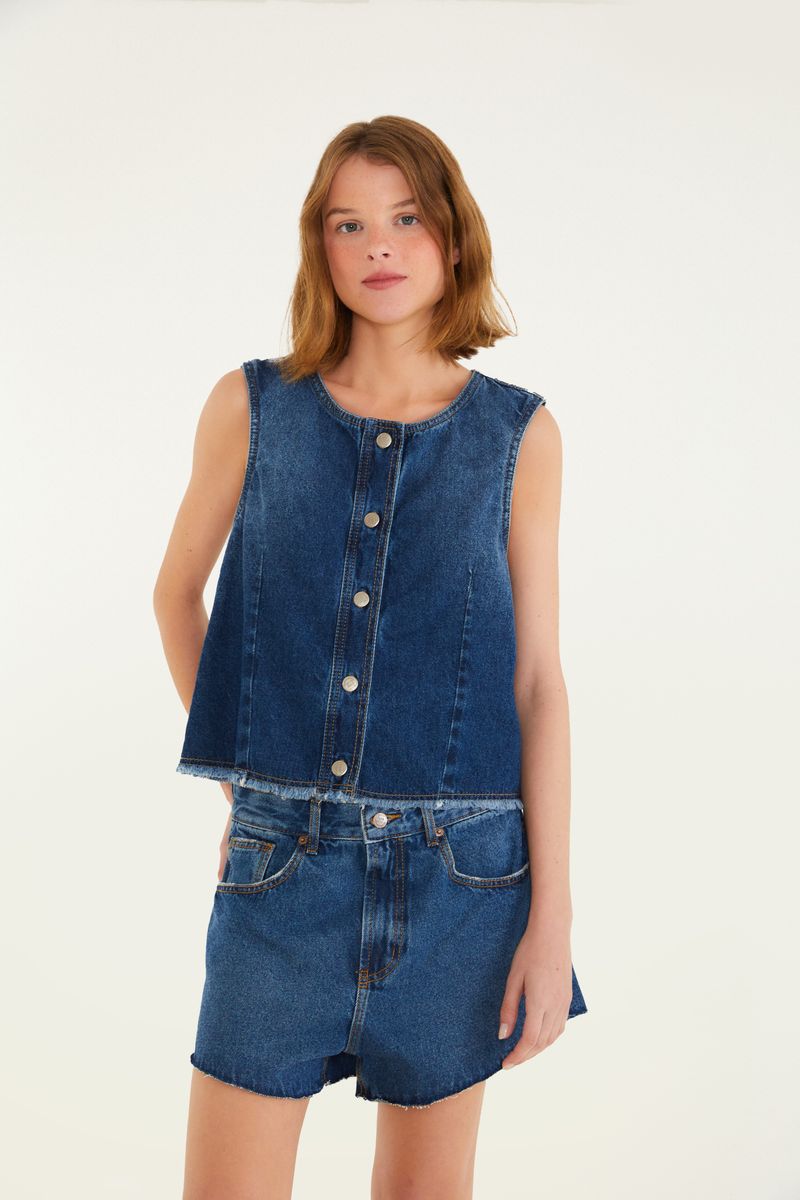 Imagen de un modelo vistiendo el conjunto de jeans visto lateralmente, destacando el corte del short.
