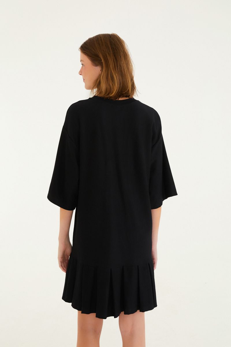 Vestido corto negro con estampado floral y texto 'Rio de Janeiro', visto de espaldas.