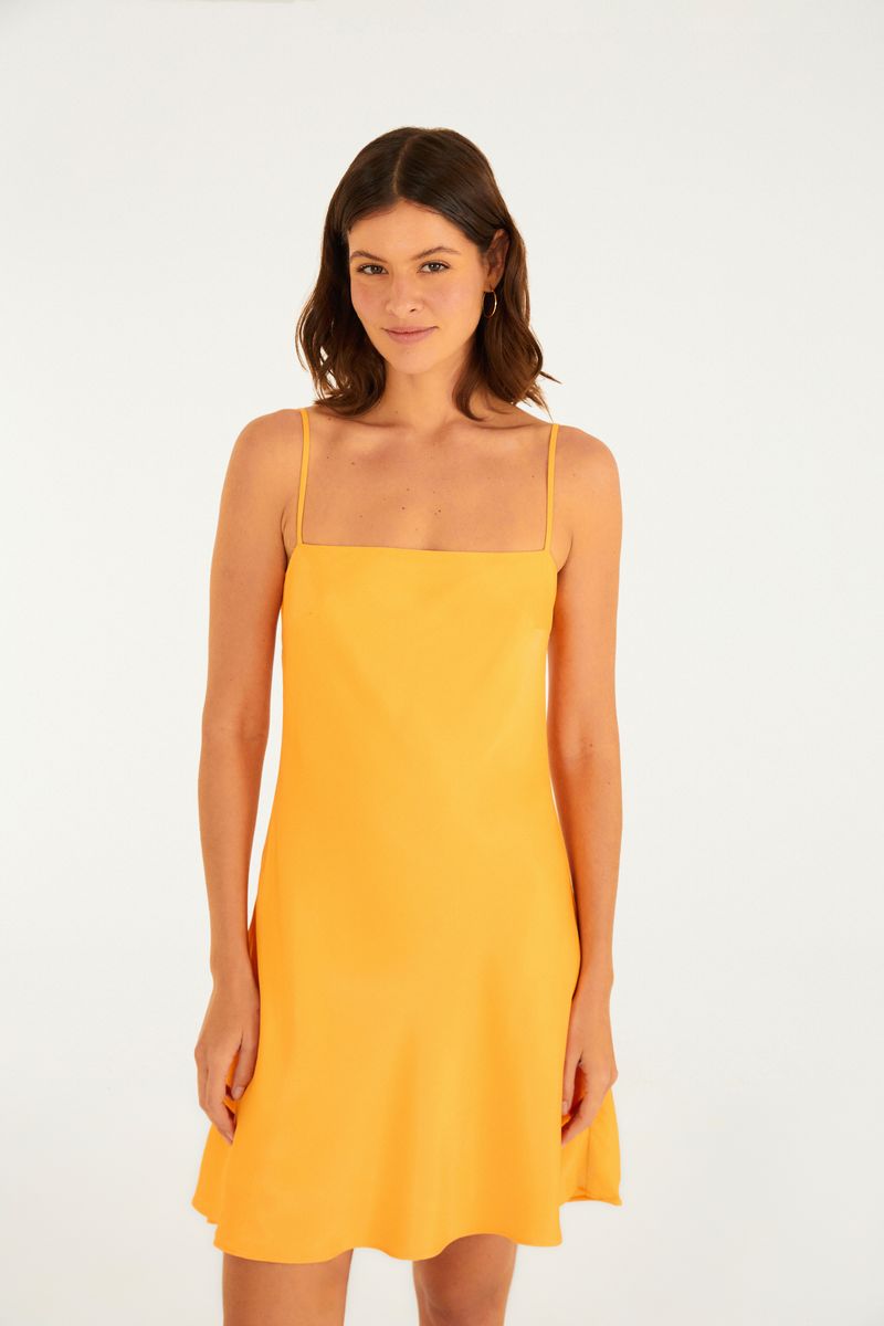 Imagen de una mujer vistiendo un vestido corto amarillo con tirantes finos, vista frontal.