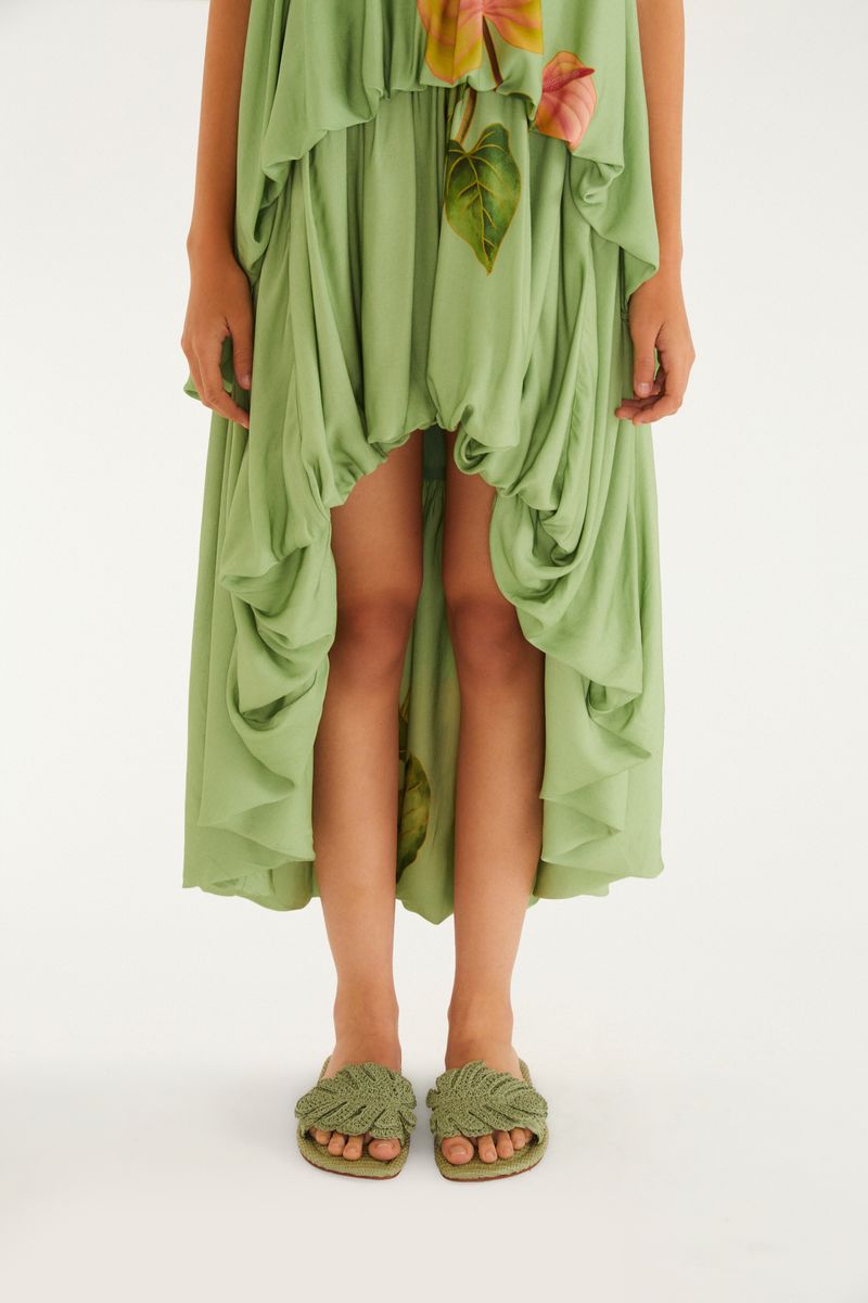 Modelo usando la sandalia con vestido verde, mostrando el estilo casual.