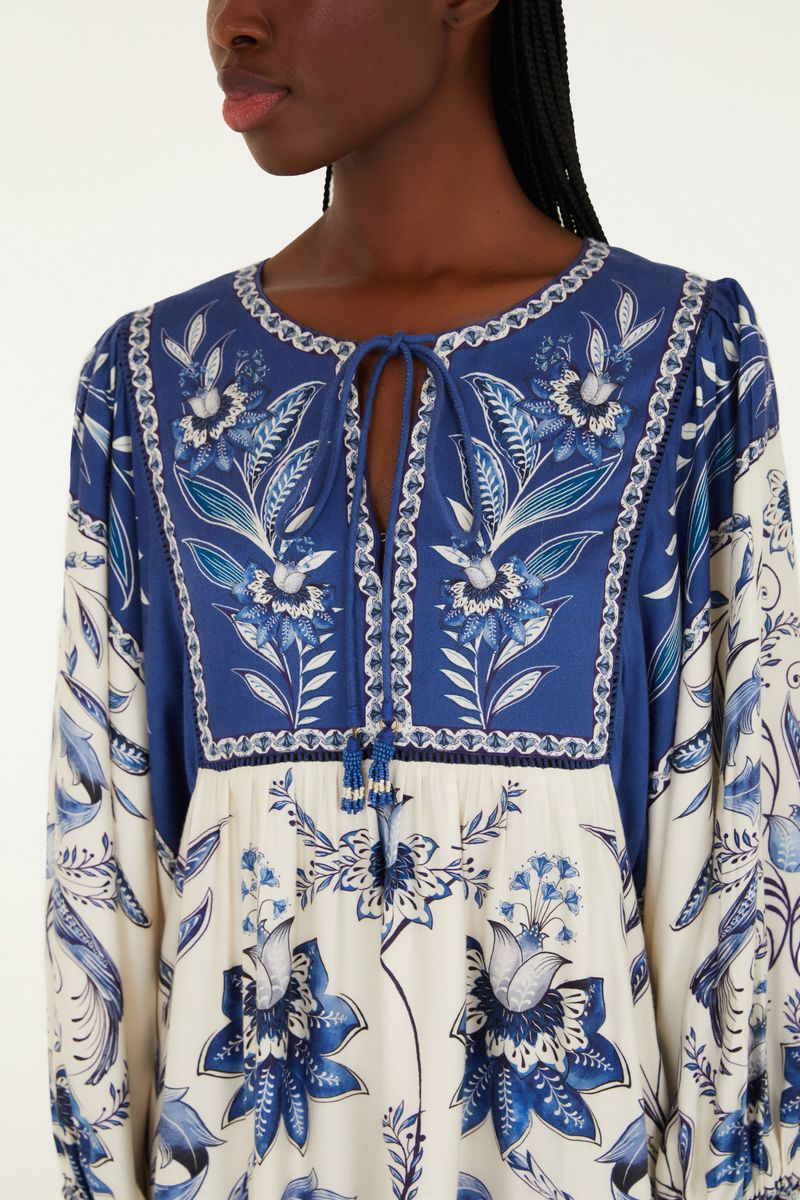 Vista trasera del vestido corto estampado con detalles florales en azul y blanco, destacando el diseño.