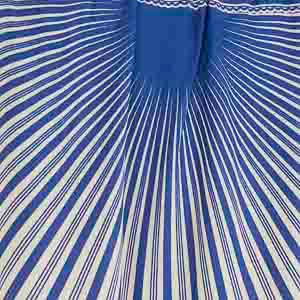 Acercamiento del estampado tropical en tonos azules y blancos del vestido largo.
