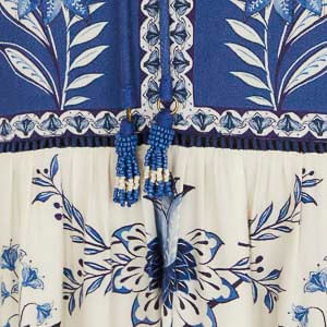 Detalle del borde del vestido corto estampado con detalles florales en azul y blanco.