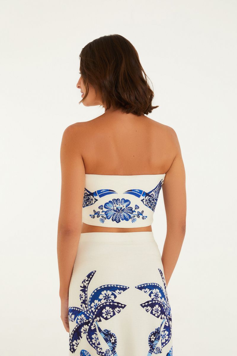 Top recto estampado tropical en azul y blanco, visto de espaldas.