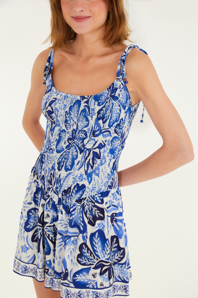 Imagen lateral del mono con estampado floral azul, destacando los tirantes finos ajustables.