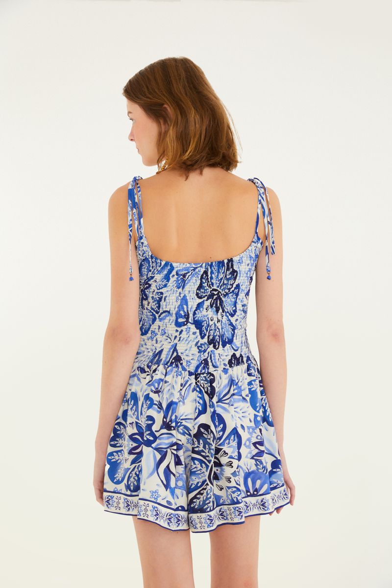 Imagen trasera del mono con estampado floral azul, mostrando el diseño de la espalda.