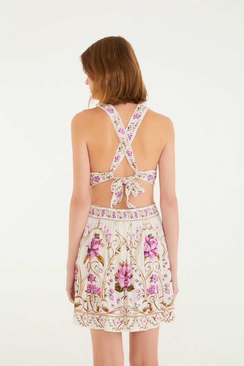 Vista trasera del vestido con tirantes cruzados y lazo decorativo.