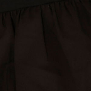 Vista lateral de la falda corta negra mostrando las capas de volantes y la costura del cinturón.